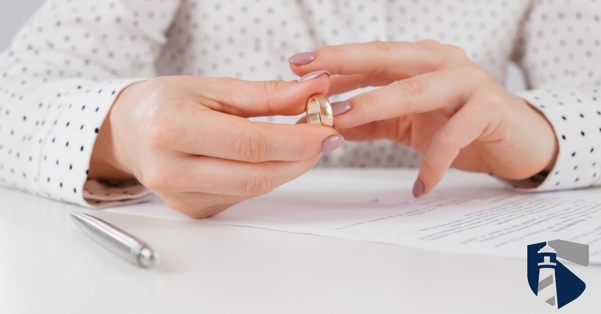 Woman signing bankruptcy papers while taking off her wedding ring